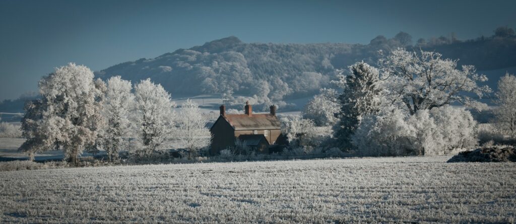 house in distant countryside with three chimneys in winter