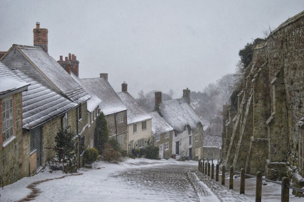 street of thatched houses in the snow